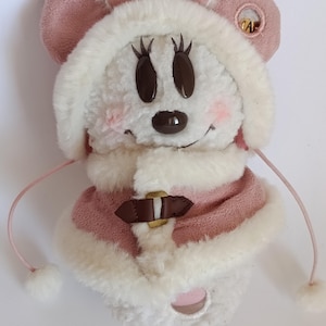 May include: A plush Minnie Mouse character in a winter outfit. The toy features a pink hat with ears, a matching coat with a faux fur trim, and a brown belt. The face has large black eyes and a small black nose.