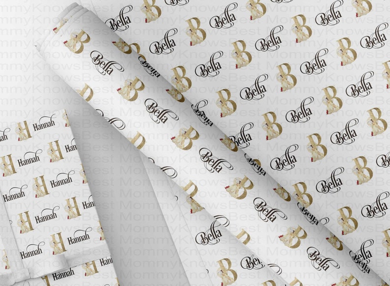 May include: White wrapping paper with a repeating pattern of the name "Bella" in a black script font and a gold-colored letter "B" with a floral design. Additional sheets feature the name "Hannah".