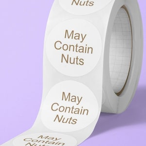 May include: Roll of white round stickers with the text "May Contain Nuts" printed in brown on each sticker.