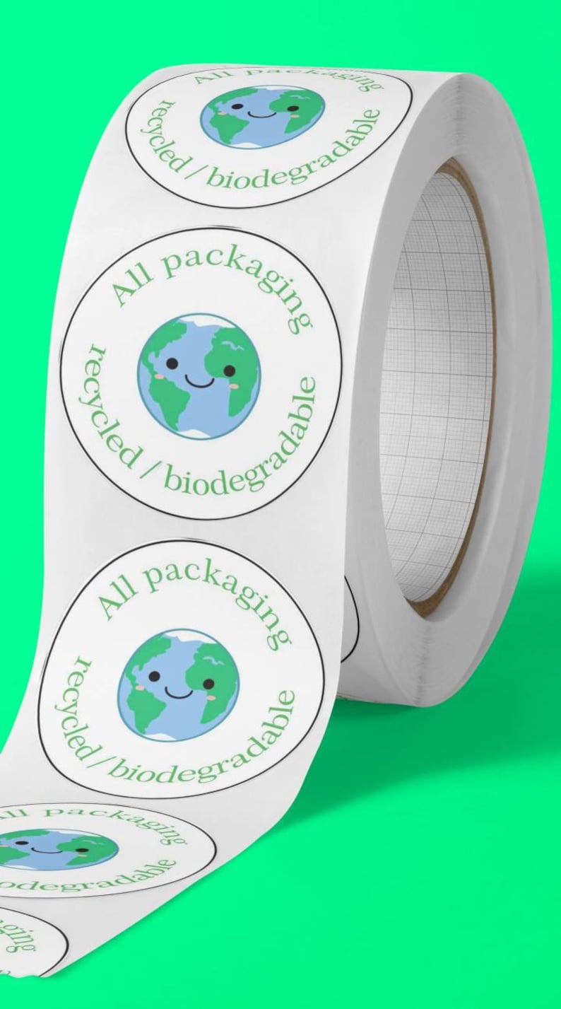 Peut inclure: Un rouleau d'autocollants circulaires blancs avec un dessin de la Terre souriante en vert et bleu. Le texte "All packaging recycled/biodegradable" est imprim&eacute; autour de la Terre. Le fond est vert vif.