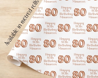 Puede incluir: Papel de regalo blanco con un patrón repetido de globos de lámina de oro rosa que dicen "Happy 80th Birthday Maureen".