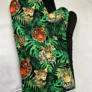 Puede incluir: Manopla de horno negra con estampado de jungla verde, blanco y naranja con tigres y leopardos.