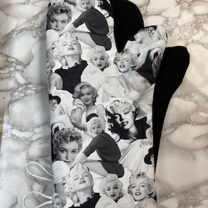 Könnte beinhalten: Schwarz-weißer Topflappen mit einer Collage von Bildern von Marilyn Monroe und anderen berühmten Frauen.