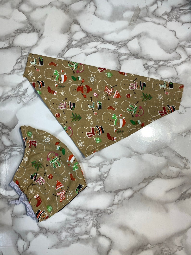 Dog bandana and Christmas Face Mask snowmen matching set. Person Dog bandana and Christmas Face Mask snowmen matching set. Person