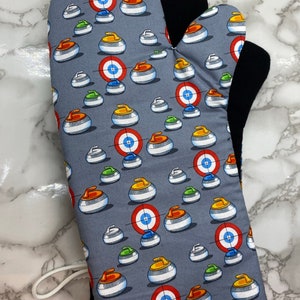 May include: A grey oven mitt with a black heat-resistant lining. The mitt features a repeating pattern of curling stones with red, blue, yellow, and green accents.