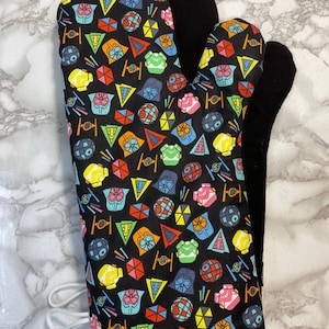 May include: A black oven mitt with a colorful pattern of Star Wars characters and symbols. The mitt is lined with black fleece.