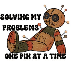 Op de afbeelding: Een bruine voodoopop met een gestikte glimlach en kruisvormige ogen ligt op zijn rug met gespreide benen. De pop heeft meerdere pinnen die eruit steken. De tekst "SOLVING MY PROBLEMS ONE PIN AT A TIME" staat onder de pop.