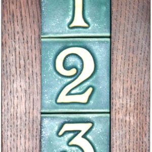 May include: A wooden frame with a green background and white numbers 1, 2, and 3. The numbers are in a decorative font.