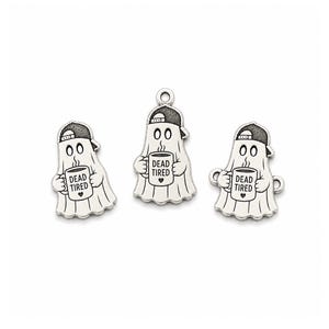 May include: Three silver-toned metal charms shaped like ghosts wearing baseball caps. Each ghost holds a mug with the text DEAD TIRED and a small heart printed on it. The charms feature engraved details and a loop at the top for attachment.