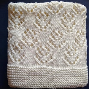 May include: A white crocheted baby blanket with a diamond pattern.