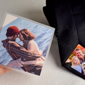Peut inclure: Une cravate noire avec une photo personnalisée imprimée à l'intérieur. Une photo carrée montre un couple s'embrassant. L'intérieur de la cravate présente un portrait de famille. Les mots "Day & Supply" sont imprimés sur la cravate.