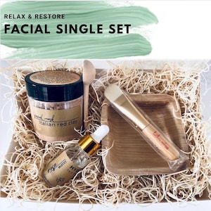 Puede incluir: Un set facial individual con un tarro de mascarilla facial de arcilla roja italiana, agua de rosas, una cuchara de madera, un cepillo y un plato cuadrado peque&ntilde;o. El set est&aacute; en una caja con paja y el texto "RELAX & RESTORE FACIAL SINGLE SET".