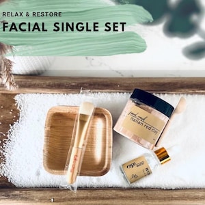 Puede incluir: Un juego facial individual con una bandeja de madera, un cuenco peque&ntilde;o de madera, un cepillo, un tarro de mascarilla facial de arcilla roja italiana y una botella de agua de rosas. El texto "Relax & Restore" y "Facial Single Set" son visibles.