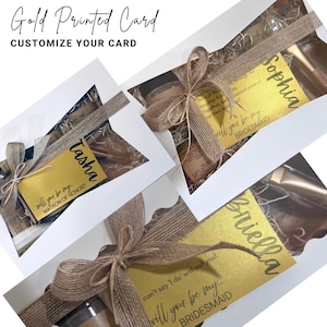 Puede incluir: Cajas de regalo con tarjetas doradas que dicen "&iquest;Quieres ser mi...?" para damas de honor y una madrina. Cada caja est&aacute; atada con una cinta de arpillera y contiene peque&ntilde;os regalos. El texto "Gold Printed Card" y "Customize Your Card" est&aacute;n en la parte superior.