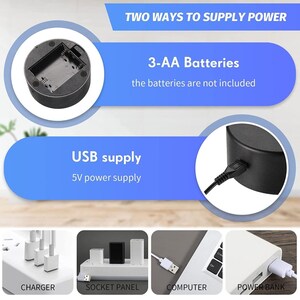 May include: A black circular base with a compartment for three AA batteries. The base has a USB port for charging. The text "TWO WAYS TO SUPPLY POWER" is displayed above the base. The text "3-AA Batteries" is displayed below the base. The text "the batteries are not included" is displayed below the text "3-AA Batteries". The text "USB supply" is displayed above the base. The text "5V power supply" is displayed below the text "USB supply".