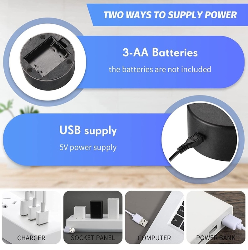 May include: A black circular base with a compartment for three AA batteries. The base has a USB port for charging. The text "TWO WAYS TO SUPPLY POWER" is displayed above the base. The text "3-AA Batteries" is displayed below the base. The text "the batteries are not included" is displayed below the text "3-AA Batteries". The text "USB supply" is displayed above the base. The text "5V power supply" is displayed below the text "USB supply".