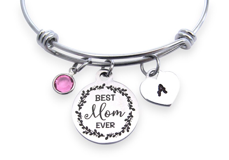 May include: Silver-tone expandable bracelet with three charms. One charm has a pink gemstone, another has the words "Best Mom Ever" in a wreath, and the third is a heart with the letter "A".