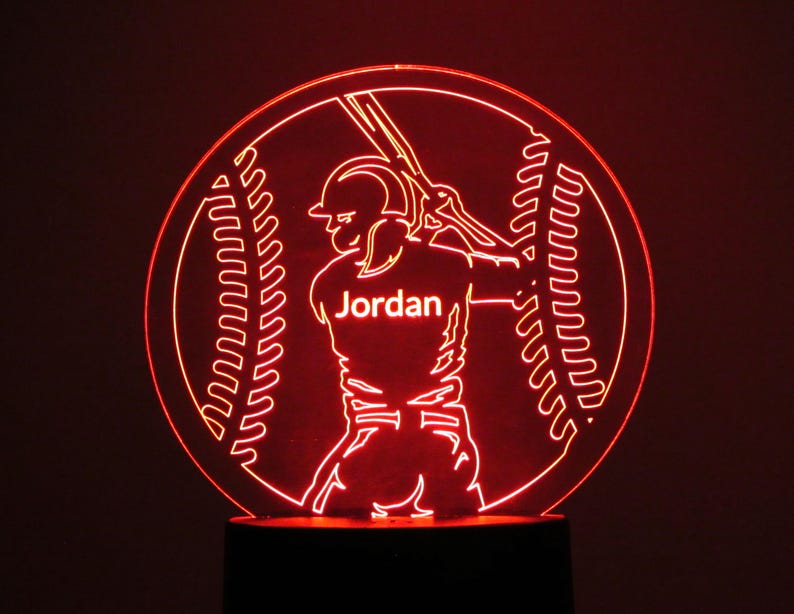May include: Red illuminated baseball night light with a baseball player silhouette holding a bat and the name "Jordan" on the jersey.