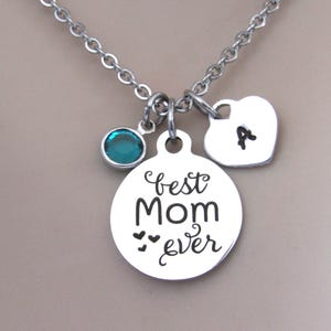 May include: Silver necklace with a round charm that says "best mom ever" with three small hearts, a heart charm with the letter "A" and a teal blue crystal charm.