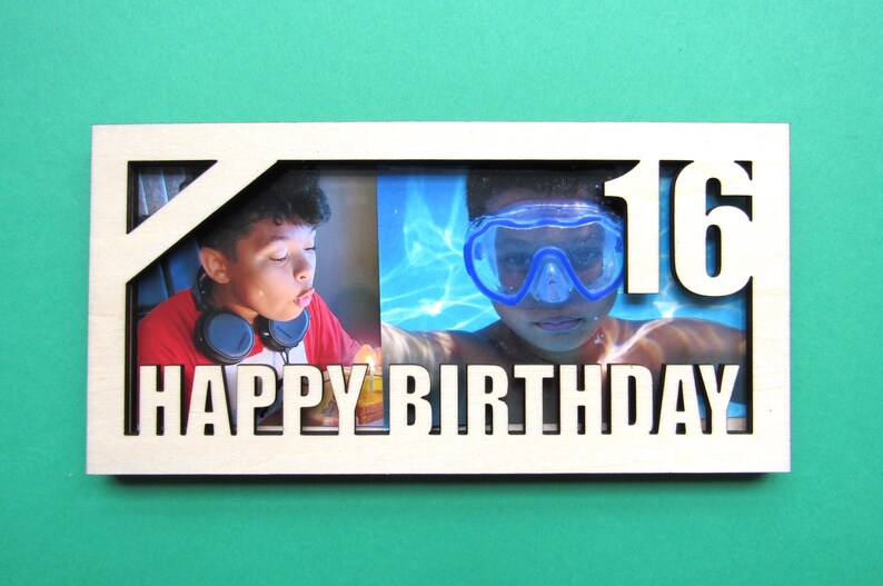 May include: A wooden photo frame with a white background and a cutout design. The frame has two photos, one of a person blowing out a candle and another of a person swimming. The frame says "Happy Birthday" and "16" in white letters.