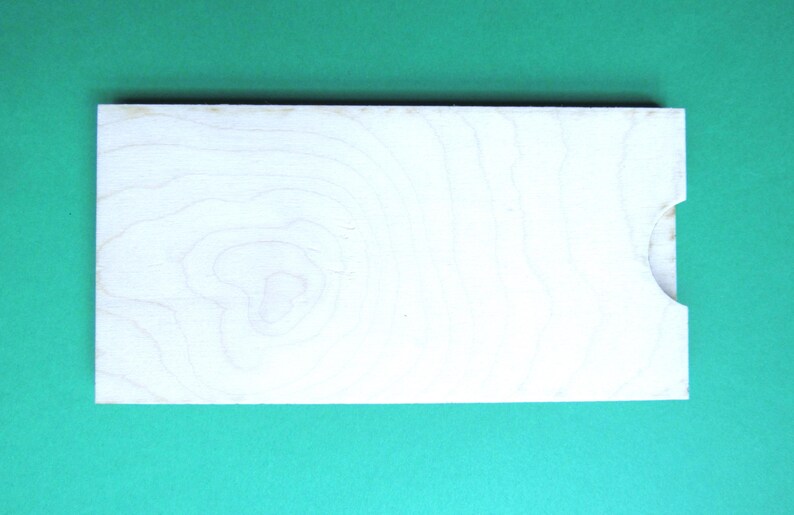 May include: A plain white wooden board with a natural wood grain pattern. The board has a small cutout on the right side.