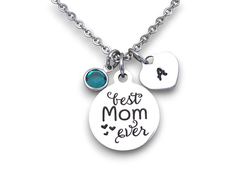 May include: Silver necklace with a round charm that says "best mom ever" with two small hearts, a teal blue crystal charm, and a heart charm with the letter "A" engraved on it.