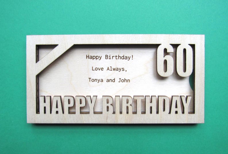 May include: A wooden card with a cutout design that says "Happy Birthday!" and "60" in large numbers. The card also has the text "Love Always, Tonya and John" inside the cutout.