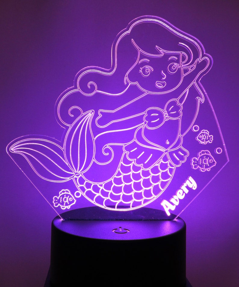 May include: A purple mermaid night light with a white outline and the name Avery. The light is on a black base with an on/off switch.