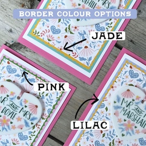 May include: Three cards with floral patterns and scalloped edges. Each card has a different colored border: pink, jade, and lilac. The text "BORDER COLOUR OPTIONS" is at the top of the image.