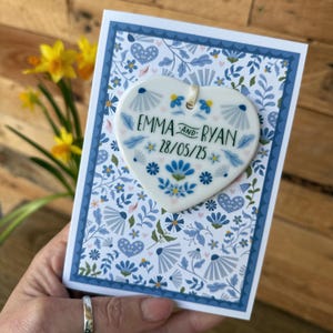Tarjeta de boda de lujo en azul con un corazón de cerámica como recuerdo - Boda griega - Personalizada con los nombres y la fecha de la pareja - Mediterránea