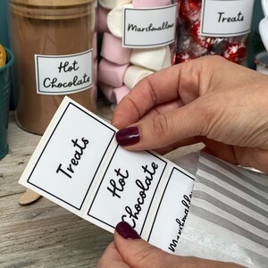 Peut inclure: Un ensemble de trois &eacute;tiquettes blanches avec du texte noir. Les &eacute;tiquettes indiquent "Treats", "Hot Chocolate" et "Marshmallows".