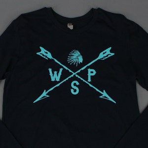 May include: A navy blue long-sleeved shirt with a turquoise graphic of two crossed arrows with a Native American headdress in the center. The letters WSP are in the center of the arrows.