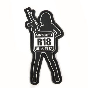 Könnte beinhalten: Schwarz-weißes Patch mit einer Silhouette einer Person, die ein Gewehr hält. Das Patch trägt den Text "AIRSOFT R18 成人向け".