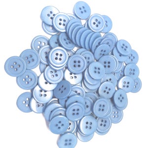 Puede incluir: Un montón grande de botones de plástico azul claro, cada uno con cuatro agujeros. Todos los botones son del mismo tamaño y forma.
