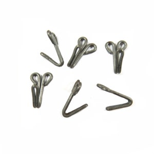 May include: Six silver metal hooks for attaching curtains or other fabric to a rod. The hooks have a double loop design for added security.