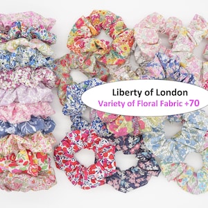 May include: A collection of fabric hair scrunchies featuring various floral patterns in colors including pink, blue, red, and yellow. A central white oval contains the text Liberty of London and Variety of Floral Fabric +70.