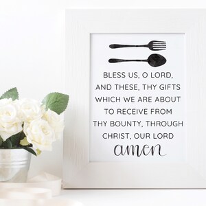 Puede incluir: Una impresión enmarcada en blanco con un diseño en blanco y negro de un tenedor y una cuchara con el texto "Bless us, O Lord, and these, Thy gifts which we are about to receive from Thy bounty, through Christ, our Lord amen".