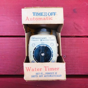May include: Vintage Sherman water timer in its original cardboard box. The timer has a cream-colored face with a black dial and numbers. The box reads "TIME OFF Automatic" and "Water Timer".