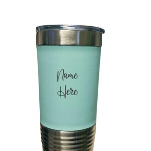 May include: A light blue stainless steel tumbler with a silver lid and base. The tumbler has the text "Name Here" printed on the side.