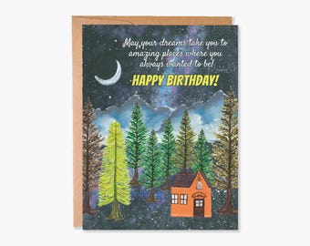May include: A birthday card with a starry night sky background. The card features a small orange house with a yellow door and a message that reads "May your dreams take you to amazing places where you always wanted to be! Happy Birthday!"