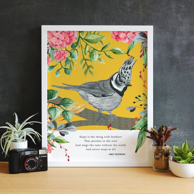 May include: A framed print with a yellow background featuring a bird with gray and white feathers perched on a branch. The bird is surrounded by pink and green flowers. The print includes a quote by Emily Dickinson: "Hope is the thing with feathers That perches in the soul And sings the tune without the words And never stops at all -EMILY DICKINSON"