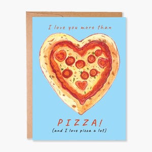 May include: A light blue card with a brown border. The card features a hand-drawn illustration of a heart-shaped pizza with red pepperoni and a white background. The text on the card reads "I love you more than PIZZA! (and I love pizza a lot)"