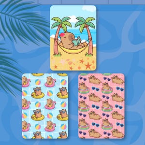 May include: Three rectangular cards featuring capybara illustrations. The top card shows a capybara in a hammock between palm trees reading a book. The bottom left card has a blue grid pattern with capybaras in floats. The bottom right has a pink grid.