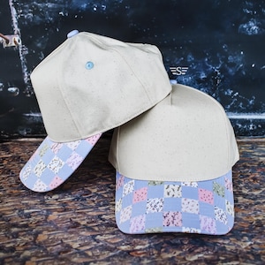 May include: A set of three ceramic mugs with a speckled, matte finish. The mugs are in shades of cream, light gray, and dark gray. Each mug has a simple, minimalist design and a rounded handle.