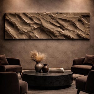 Könnte beinhalten: Modernes Interieur mit einer strukturierten Wandverkleidung in Felsoptik. Die Platte hat einen hellbraunen Farbton und befindet sich über einem dunklen, runden Couchtisch. Der Raum ist mit braunen Sesseln ausgestattet.