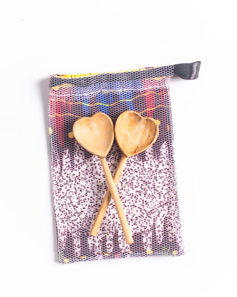 May include: Two wooden heart-shaped spoons in a mesh bag with a colorful patterned design.