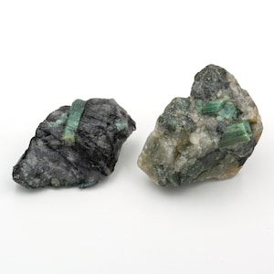 Two rough emeralds of 118 and 178 grams with a quartz and mica matrix.
