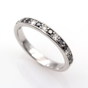 18k/750 white gold half-weave ring with 0.10ct. of white diamonds and 0.20ct. of black moissanites.