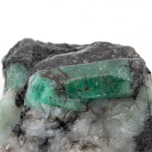 133 gram rough emerald with quartz and mica matrix. Translucent emerald crystal.