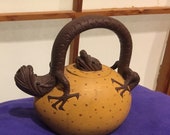 A Dragon s Egg Tea Pot, he s on it, with full attention. The chop mark on the pot is his name. Wow. How about a cuppa for peace, big guy